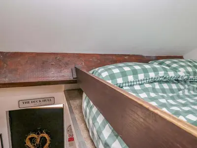 two bunk beds in a room with a book at High Wreah Bolt Hole in Whitehaven
