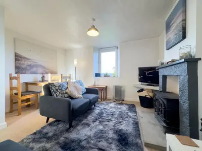 a living room with a couch and a fireplace at Escape to our Cosy Cottage with Log Burner in Drigg, Lake District in Drigg