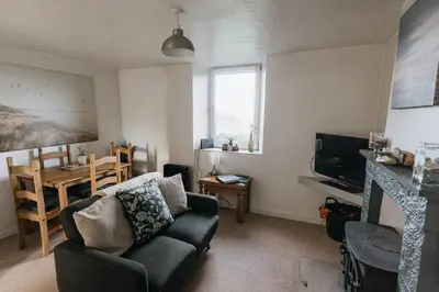 a living room with a couch and a table at Escape to our Cosy Cottage with Log Burner in Drigg, Lake District in Drigg