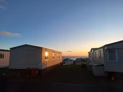 two mobile homes with the ocean in the background at Winnie - Caravan mit Meerblick in Drummore