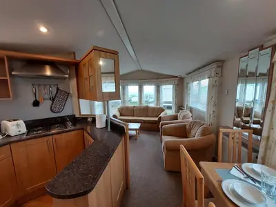 a kitchen and living room of a caravan at Winnie - Caravan mit Meerblick in Drummore
