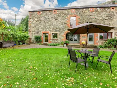 a table and chairs with an umbrella in a yard at 2 Bed in Keswick oc-28383 in Braithwaite