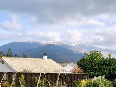 a house with a fence and mountains in the background at 2 Bed in Keswick 28377 in Braithwaite