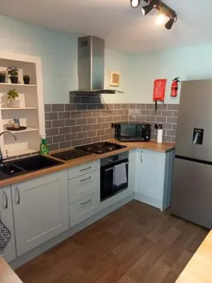 a kitchen with white cabinets and a stove top oven at Fleet Townhouse in Gatehouse of Fleet