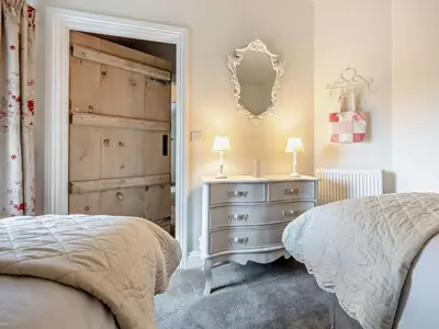 a bedroom with a bed and a dresser and a mirror at 2 Bed in Bridekirk 93280 in Bridekirk