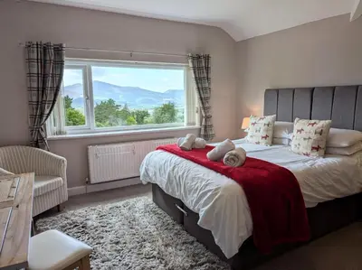 a bedroom with a bed with a red blanket and a window at 3 Bed in Keswick 93202 in Keswick