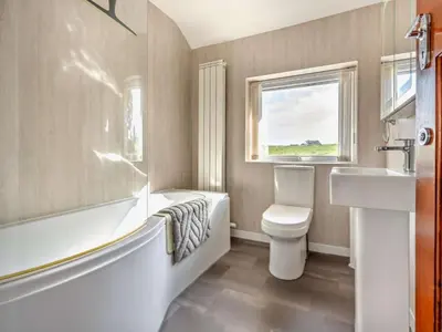 a bathroom with a tub and a toilet and a sink at 3 Bed in Keswick 93202 in Keswick