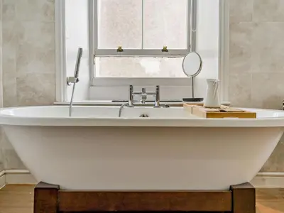 a white bath tub with a mirror and a sink at 1 Bed in Cockermouth oc-93147 in Cockermouth
