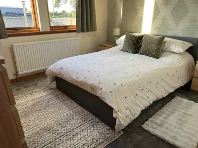 a bedroom with a bed with a white comforter and a window at 3 Bed in Mochrum 87541 in Mochrum