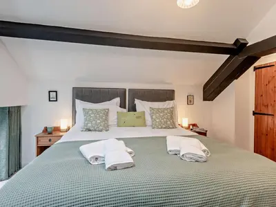 a bedroom with a large bed with two towels at 2 Bed in Ambleside oc-sz500 in Grasmere