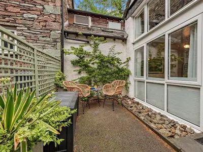 a patio with a table and chairs next to a building at 2 Bed in Ambleside oc-sz500 in Grasmere