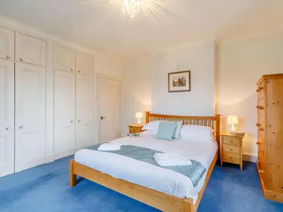 a bedroom with a large bed with white cabinets at 4 Bed in Cockermouth oc-85979 in Buttermere
