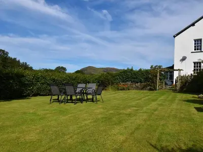 a group of chairs sitting on a lawn next to a house at 4 Bed in Cockermouth oc-85979 in Buttermere