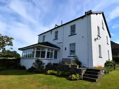a large white building with windows on a grass field at 4 Bed in Cockermouth oc-85979 in Buttermere