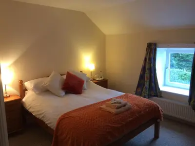 a bedroom with a bed with two towels on it at The Village Inn in Kirtlebridge