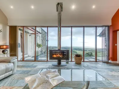 a living room with a fireplace and large windows at 4 Bed in Broughton Mills 75286 in Seathwaite