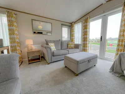 a living room with a couch and a table at Serena Holiday Caravan in Bassenthwaite
