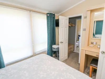 a bedroom with a bed and a desk and a window at A and C Lodge-Plot 21 in Carlisle