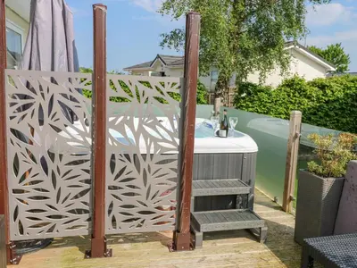 a privacy fence with a table on a deck at A and C Lodge-Plot 21 in Carlisle