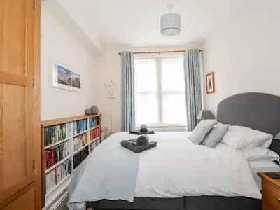 a bedroom with a bed and a book shelf with books at Walla Crag, Royal Oak House in Keswick