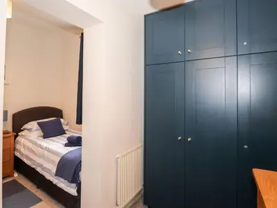 a bedroom with a blue cabinet next to a bed at Walla Crag, Royal Oak House in Keswick
