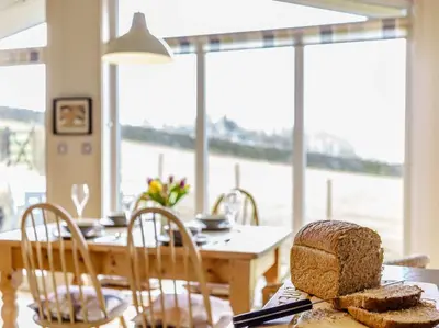 a dining room with a table with a loaf of bread at 2 Bed in Caldbeck 80562 in Caldbeck