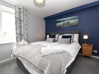 a bedroom with blue walls and a bed with towels at 1 Bed in Keswick SZ468 in Keswick