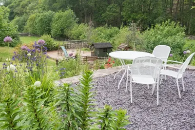 a table and chairs sitting in a garden at 2 Bed in Eskdale SZ346 in Santon Bridge