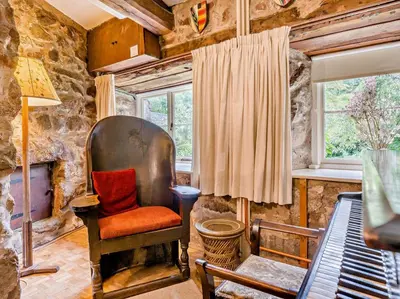 a stone room with a chair and a window at 4 Bed in Holmrook oc-sz158 in Eskdale