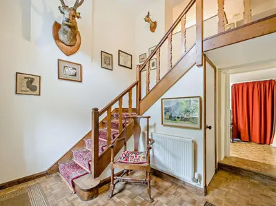 a wooden staircase in a home with a chair at 4 Bed in Holmrook oc-sz158 in Eskdale