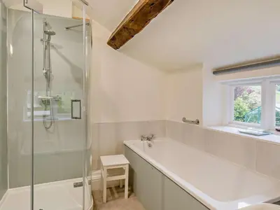 a bathroom with a tub and a glass shower at 4 Bed in Holmrook oc-sz158 in Eskdale