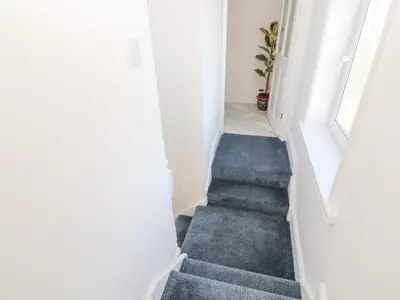 a staircase in a house with blue carpet at Hillside Hideaway in Wigton