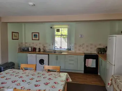 a kitchen with a table and a kitchen with a table and chairs at The Coach House - Bargany in Girvan