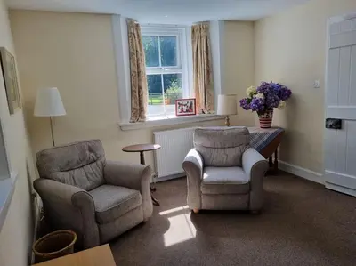 a living room with two chairs and a table at The Coach House - Bargany in Girvan