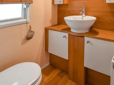a bathroom with a sink and a toilet at Inglenook Lodge in Lamplugh