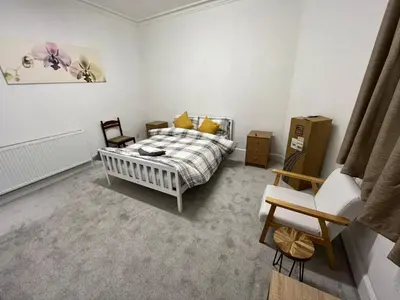 a bedroom with a bed and a chair at Luxury 1BR Flat Central Dumfries Self Check-in, Parking, Wi-Fi in Dumfries