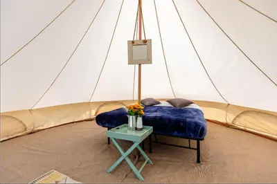 a room with a bed and a table in a tent at Duke Travel Official TT Glamping - Douglas in Kirk Braddon