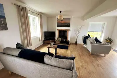 a living room with a couch and a tv at ERIN NEAMH - Magnificent sea views cosy cottage in Cumbria in Harrington