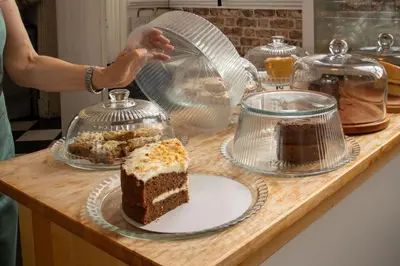 a person is making a piece of cake on a counter at Shepherds Hut at Maes Uldale stunning fell views and next door to popular cafe for sweet treats in Uldale
