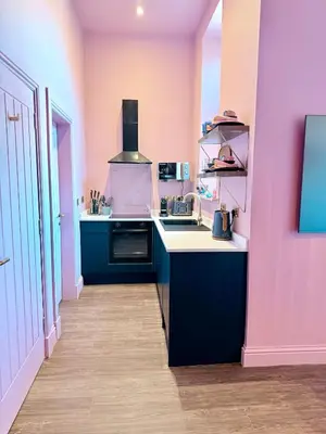 a kitchen with pink and purple walls and a stove at The Bank - Rooms & Apartments by Coorie Doon Stays in Troon