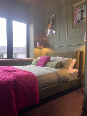 a bedroom with a bed with purple blankets and pillows at The Bank - Rooms & Apartments by Coorie Doon Stays in Troon