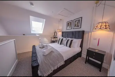 a bedroom with a large bed and a window at The Bradan - Troon - Coorie Doon Stays in Troon