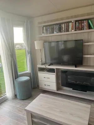 a living room with a flat screen tv on a entertainment center at GDs Luxury Caravan Hire Turnberry Holiday Park in Turnberry