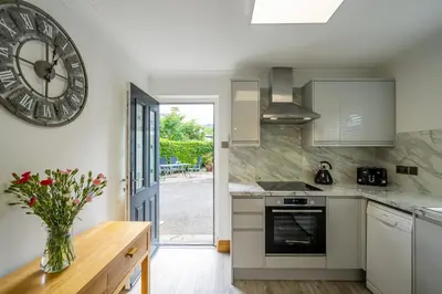 a kitchen with a large clock on the wall at Acorn Apartment 1 in Keswick