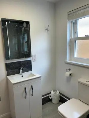 a white bathroom with a sink and a toilet at Acorn Apartment 1 in Keswick