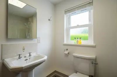 a white bathroom with a sink and a toilet at Acorn Apartment 1 in Keswick