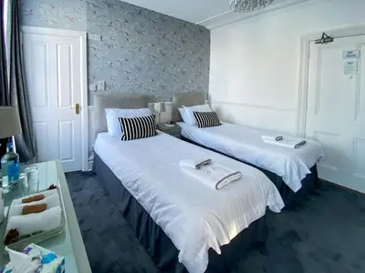 two beds in a hotel room with white sheets at Number 10 Bed & Breakfast in Keswick