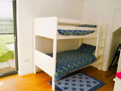 a room with two bunk beds and a rug at The Longhouse in Castle Douglas