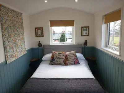 a small bedroom with a bed with two pillows at The Mad Hatter's Shepherd's Hut in Carlisle