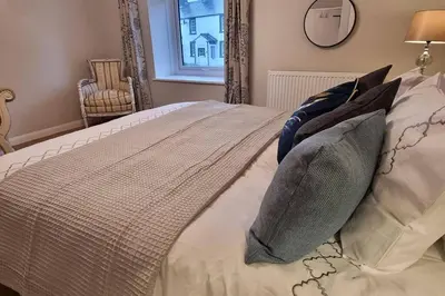 a bedroom with a bed with pillows and a window at Luxury Lake District Retreat above Ennerdale in Kirkland